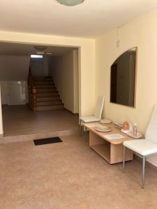 sala de estar con mesa, sillas y escaleras en Borko Guest House en Primorsko