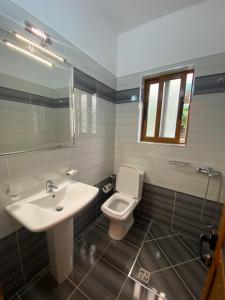 a bathroom with a sink and a toilet and a mirror at Hotel Fron in Sarandë +207 photos