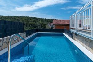 a swimming pool on the balcony of a house at Apartments Kapetan in Trogir