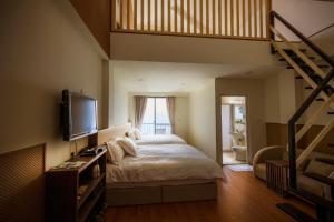 una camera da letto con un letto grande e una scala di Le Retour Du Printemps Villa a Ren'ai