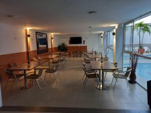 un restaurante con mesas y sillas y una piscina en Hotel Napolitano en Villavicencio