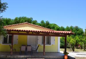 a small yellow house with a pergola at Cozy cottage with garden and olive grove of 5 acr in Mavráta