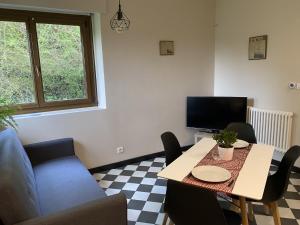 salon ze stołem i telewizorem w obiekcie AILE DU CHATEAU 6 personnes w mieście Lebétain