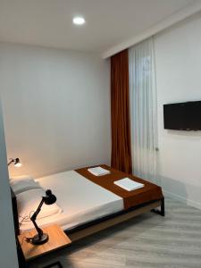 Un pat sau paturi într-o cameră la Polifonia Inn Borjomi