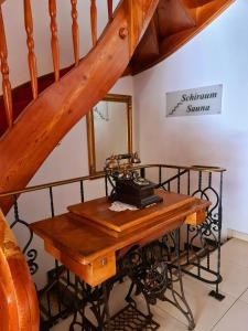 a wooden table with a sewing machine on top of a staircase at Hotel Alpenhof*** in Kaltenbach