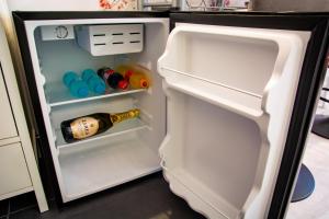 an open refrigerator with a bottle of wine in it at Pink Boutique in Campina