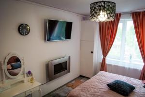 1 dormitorio con 1 cama y TV en la pared en Pink Boutique, en Campina