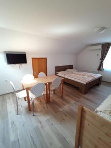 Pokój ze stołem, krzesłami i łóżkiem w obiekcie Apartments Vila Leska w mieście Zgornji Leskovec