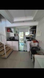 eine Küche mit weißen Schränken und einem weißen Boden in der Unterkunft Casa de Praia em Condomínio Fechado in Guarujá