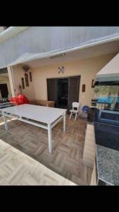 ein Wohnzimmer mit einem weißen Tisch und einer Couch in der Unterkunft Casa de Praia em Condomínio Fechado in Guarujá