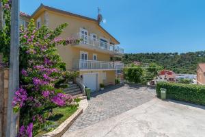 a house with purple flowers on the side of it at Apartments Kapetan in Trogir