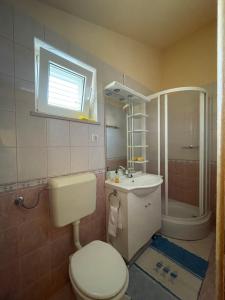 Un baño con inodoro, lavabo y ducha. en Apartment Nikola, en Rogoznica