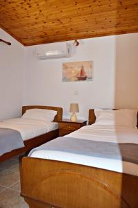een slaapkamer met 2 bedden en een tafel met een lamp bij Cozy cottage with garden and olive grove of 5 acr in Mavráta