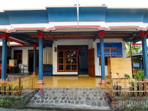 un edificio azul y blanco con una puerta delante en OYO Homes 91134 Desa Wisata Tebing Lingga 