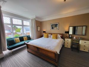 um quarto com uma cama grande e um sofá em St George's Guest House em York