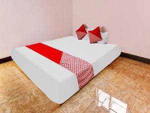 Una cama blanca con dos almohadas encima. en OYO Homes 91134 Desa Wisata Tebing Lingga 