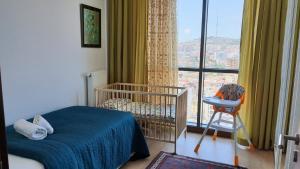 a bedroom with a crib and a large window at Panoramic scenery, Pool, Turkish Bath, Sauna, Gym, 3BRoom,1 Living Room 2Bathroom and Much More in Istanbul