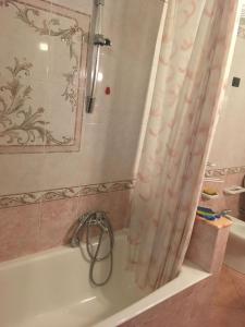 a bathroom with a bath tub with a shower curtain at CASA VACANZE AMBRA in Gioiosa Marea