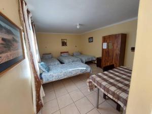 una sala de estar con dos camas y un sofá en Skippers Backpackers CC, en Walvis Bay
