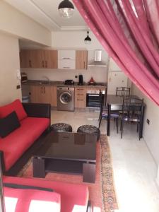 salon z czerwoną kanapą i stołem w obiekcie Agréable appartement au coeur de Guéliz, Marrakech w Marakeszu