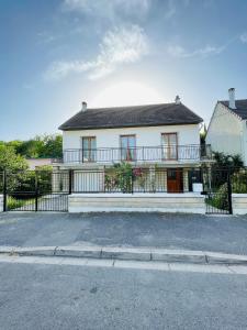 a white house with a fence in front of it at Super maison entre paris et Disney in Chelles