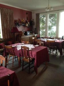 une salle à manger avec des tables, des chaises et un tissu de table rouge dans l'établissement Butlers Guesthouse, à Birregurra