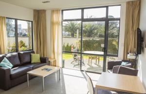 a living room with a couch and a table at Waves in Orewa