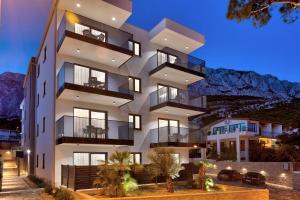 ein Gebäude mit Balkon und Bergblick im Hintergrund in der Unterkunft Apartments Amare in Promajna