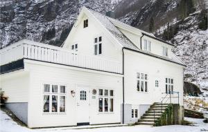 a white house with snowy mountains in the background at Nice Home In Vik I Sogn With Jacuzzi in Åse +17 photos