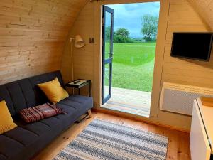 a living room with a couch and a sliding glass door at BrackenXcapes Glamping in Newark upon Trent