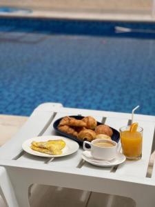 a tray of breakfast food on a table next to a pool at CasaHouse Apparts in Nouakchott