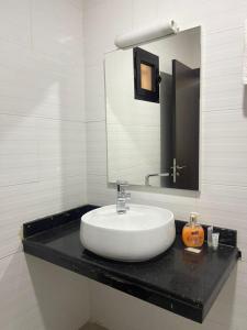 bagno bianco con lavandino e specchio di CasaHouse Apparts a Nouakchott