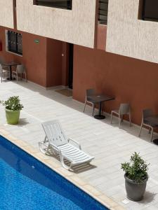 a lounge chair sitting next to a swimming pool at CasaHouse Apparts in Nouakchott