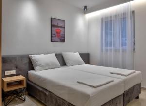 ein Bett in einem Zimmer mit einer weißen Wand in der Unterkunft Apartments Amare in Promajna