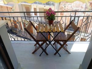 カステッランマーレ・デル・ゴルフォにあるCarpe Diem Apartmentsのテーブル、椅子、鉢植えの植物が備わるバルコニー