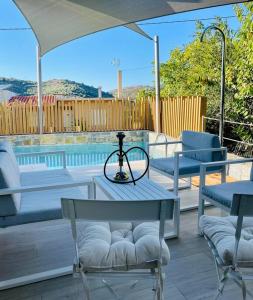 eine Terrasse mit einem Tisch, Stühlen und einem Sonnenschirm in der Unterkunft THE AA VILLA: Your Interactive Home Experience! in Kastamonítsa