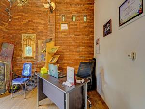 een bureau met een laptop en 2 stoelen bij OYO Homes 91142 Desa Wisata Alam Gosari (wagos) 