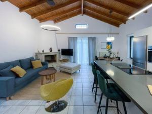 ein Wohnzimmer mit einem blauen Sofa und eine Küche mit einem Tisch in der Unterkunft THE AA VILLA: Your Interactive Home Experience! in Kastamonítsa
