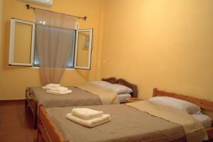 duas camas num quarto com toalhas em Antonia's Rustic Retreat em Dhórion