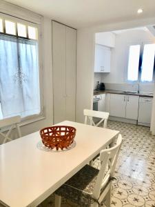 a kitchen with a white table and chairs and a table at Precioso piso en el centro neurálgico de Olot in Olot