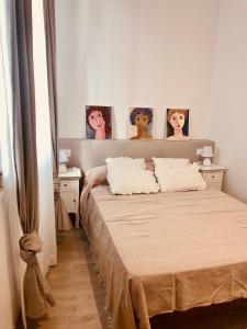 um quarto com uma cama com três fotografias na parede em Precioso piso en el centro neurálgico de Olot em Olot