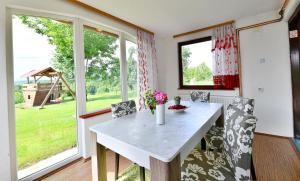 a kitchen with a table and chairs and windows at Natura hause in Rakovica