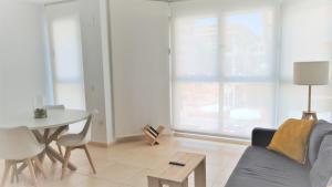uma sala de estar com um sofá e uma mesa em BEACH VALENCIA 21 - Luxury Apartament on Beach em Valência