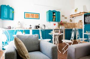a kitchen with blue cabinets and chairs in a room at La Maison d'Etrusque in Tarquinia
