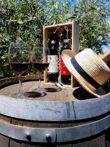dos copas de vino y un sombrero en una mesa en L'Olivo nel Chianti, en Quercegrossa