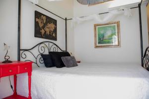 a bedroom with a white bed and a red table at La Maison d'Etrusque in Tarquinia
