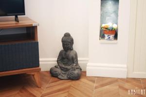 a statue sitting on the floor in a room at Habitat Central Apartment in Ruse