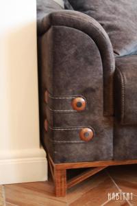 a brown leather couch with wooden drawers next to a table at Habitat Central Apartment in Ruse +36 photos