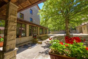 an exterior view of a building with flowers and a tree at Casa PerFerie “PASTOR ANGELICUS” in La Verna