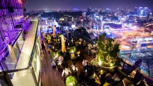 Una multitud de personas sentadas en un bar por la noche en The Rixx Luxury Apartment, en Ho Chi Minh